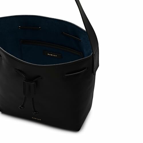 Open black leather tote bag with blue interior and drawstring closure.