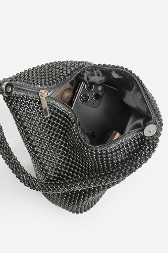 Open black studded purse with a smartphone inside.