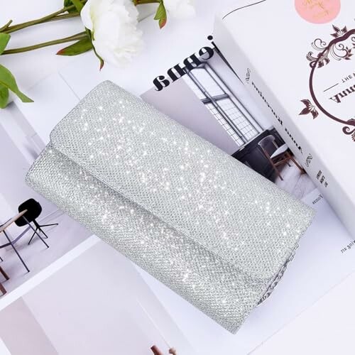 Silver glitter clutch on magazines and books.