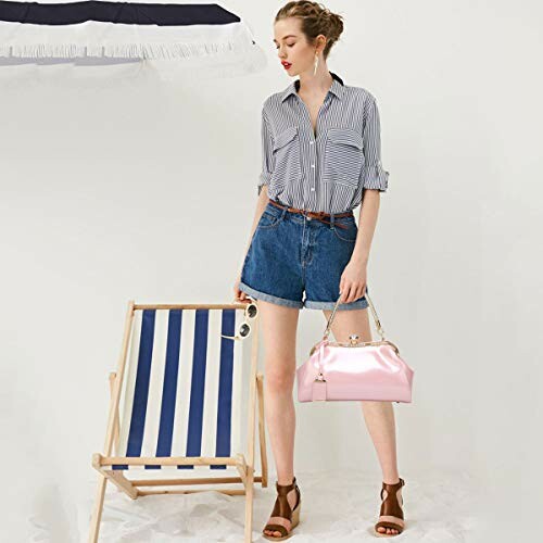 Woman in striped shirt and denim shorts with pink handbag and striped chair.